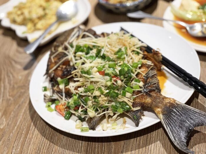 恆春（ヘンチュン）にある台湾料理のお店、北門家常菜で食べた、揚げ焼きした魚に薬味がたっぷりのった一品